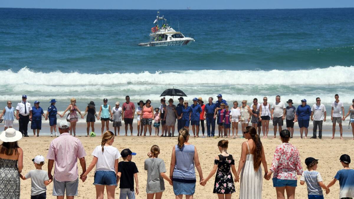 People joined hands at Watonga Rocks and stood silently for one minute. Photo: Port Macquarie News