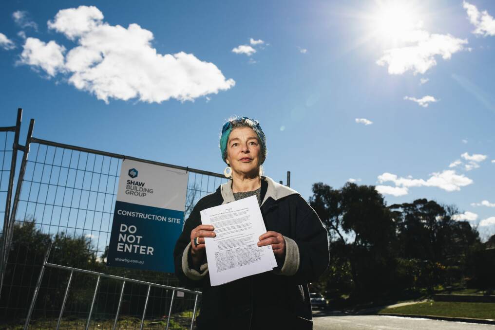 Hackett resident Tess Horwitz with a petition calling for careful development on razed Fluffy blocks in the suburb. Photo: Rohan Thomson
