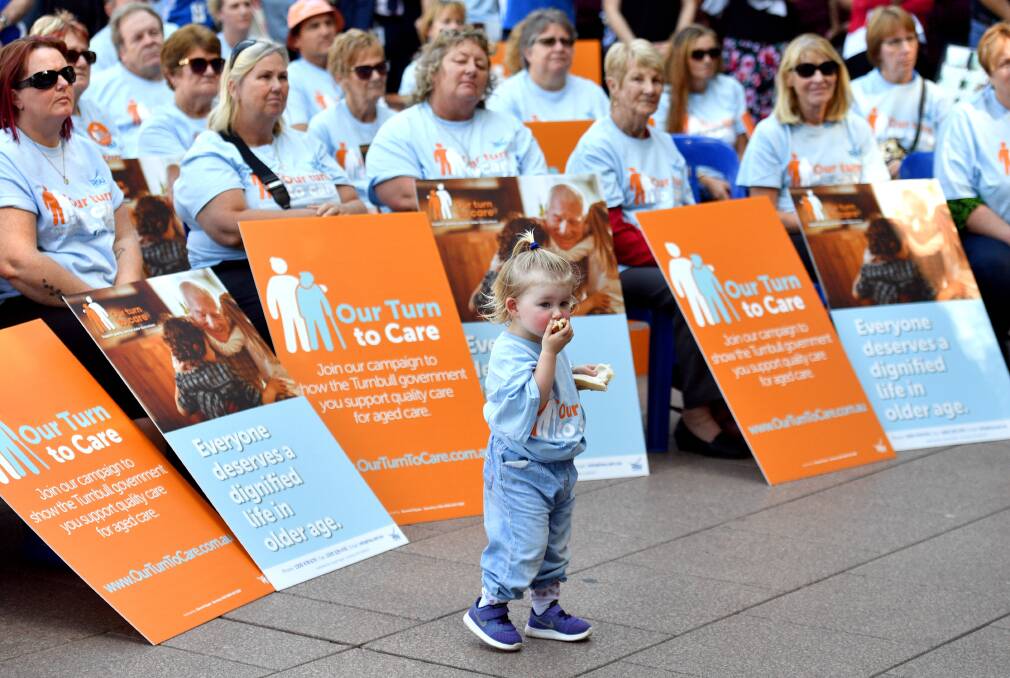 A child is seen with Health Services Union members and other affiliated unions members at a rally at Hyde Park in Sydney in April. Photo: AAP