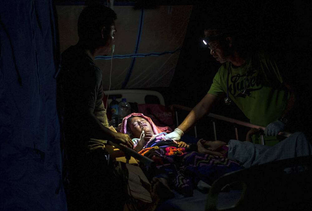 A doctor examines an injured child. Photo: AP