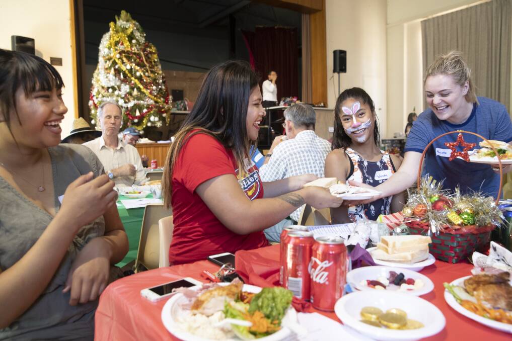 Marieta Pelenato, Anna Uelese, and Wendy Fiti, all from Kaleen, share a laugh with volunteer Nicole Applewhite over Christmas lunch at St John's Care. Photo: Sitthixay Ditthavong