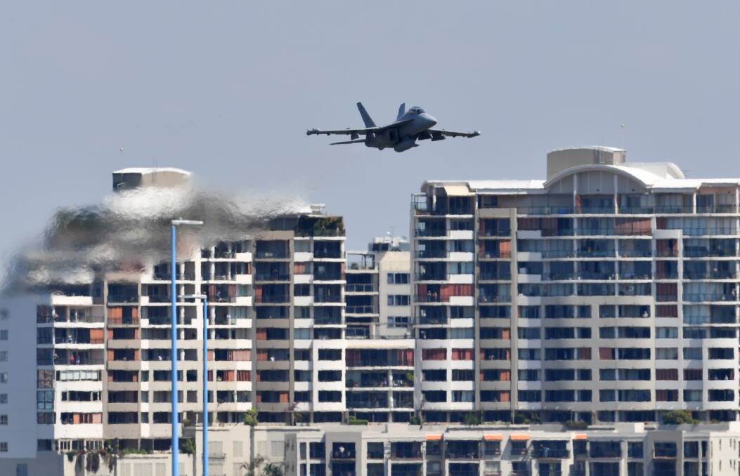 A RAAF EA-18G Growler flies over the Brisbane skyline on Friday as part of the final rehearsal for Riverfire. Photo: Darren England - AAP