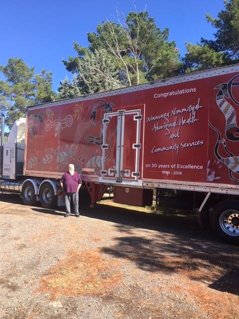 Artist Mick Huddleston with the truck he painted for Danny Palmer to help advertise the Winnunga Nimmityjah Aboriginal Health Service