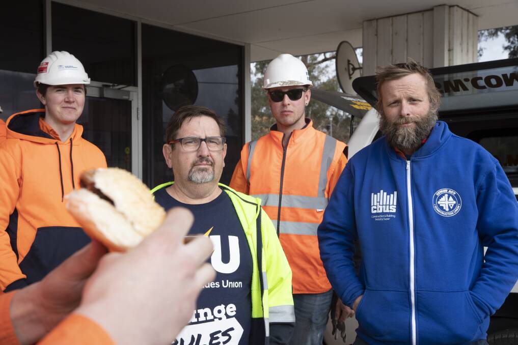 Electrical Trades Union officer Matt McCann and Construction, Forestry, Maritime, Mining and Energy Union site delegate Leon Arnold with light rail electricians at a barbecue outside the light rail depot in Mitchell on Friday. Photo: Sitthixay Ditthavong