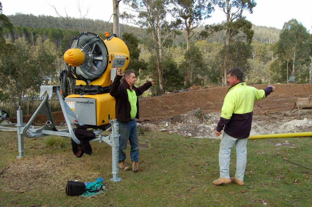 Corin Forest staff, pictured in front of the yellow snow gun, discuss plans which will see the area of snowfields doubled this winter. Photo: Supplied