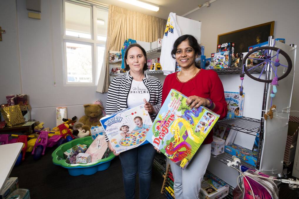 St John's Care Reid volunteers Carley Myers and Jayan Gomanthinayagam in the present room last Christmas. Photo: Dion Georgopoulos