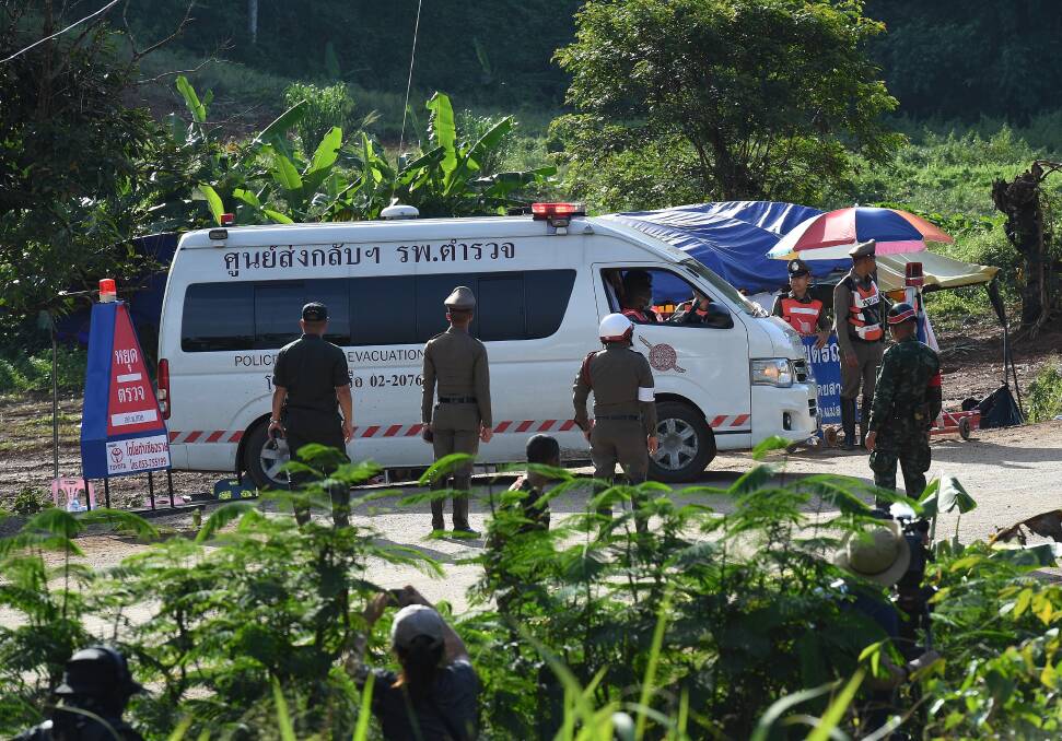 An ambulance carrying the 5th person to be rescued from Tham Luang cave drives past the caves park entrance. Photo: Kate Geraghty