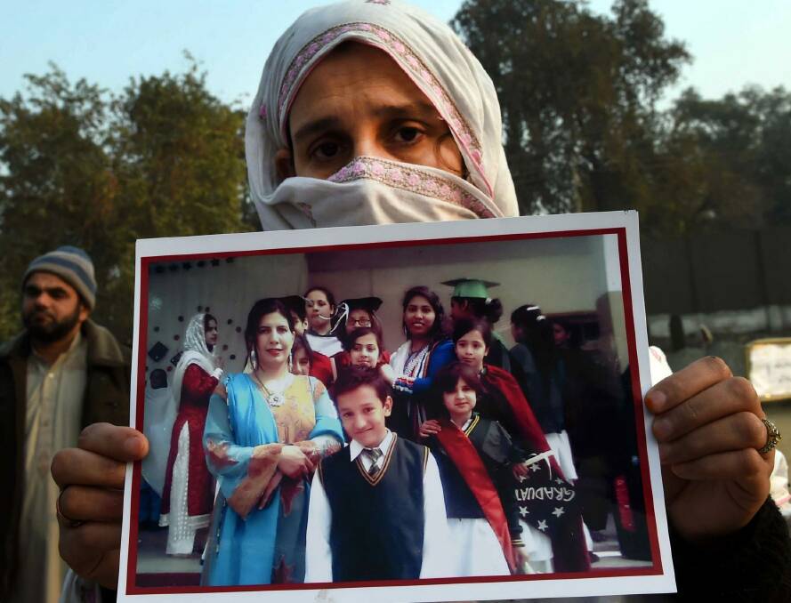 Slaying: A woman holds a photograph of her son after his death during the massacre by Taliban militants. Photo: A Majeed