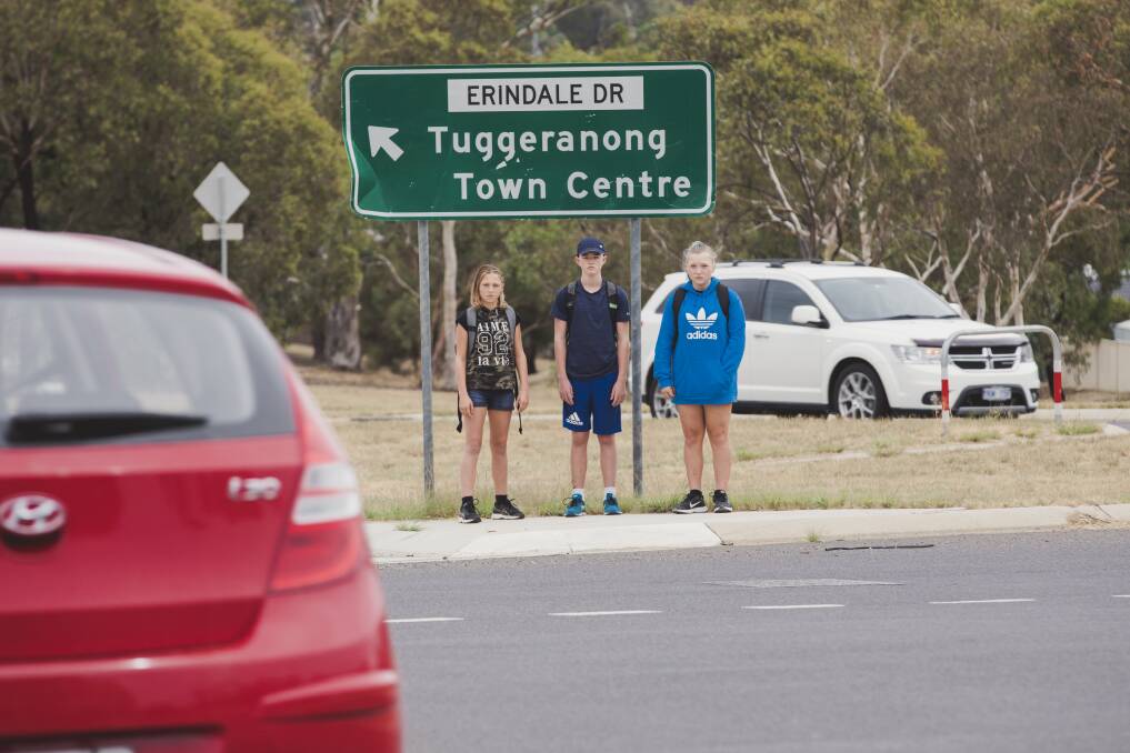Sisters Cerys Simmons, 12, left, and Rhiannon Simmons, 14, right, wait with classmate Harry, 14, centre, to cross a  busy roundabout. Photo: Jamila Toderas