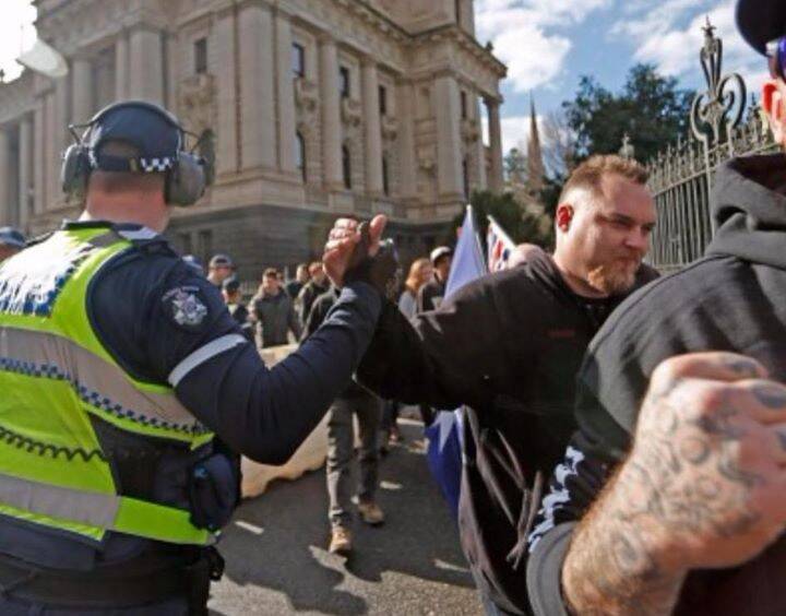 A Victorian police officer appears to give a Reclaim Australia supporter a solidarity handshake at a rally on Sunday. Photo: Meredith O'Shea