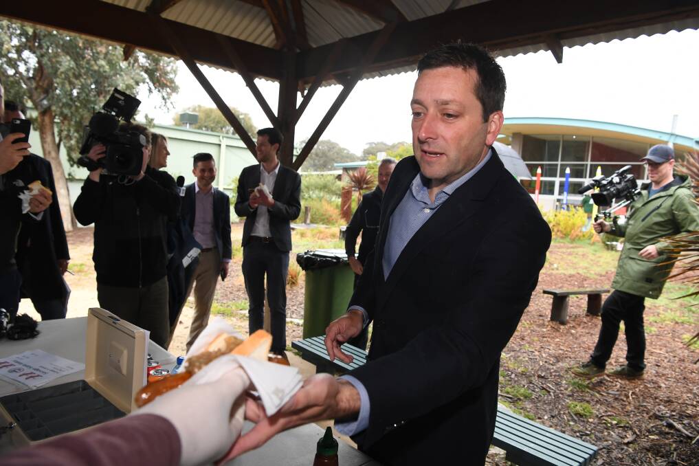Matthew Guy with his democracy sausage on Saturday morning.  Photo: AAP