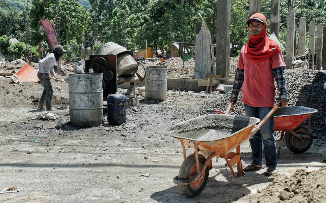 Amrulah working at a construction site in his village of Nipah in north Lombok. Photo: Amilia Rosa