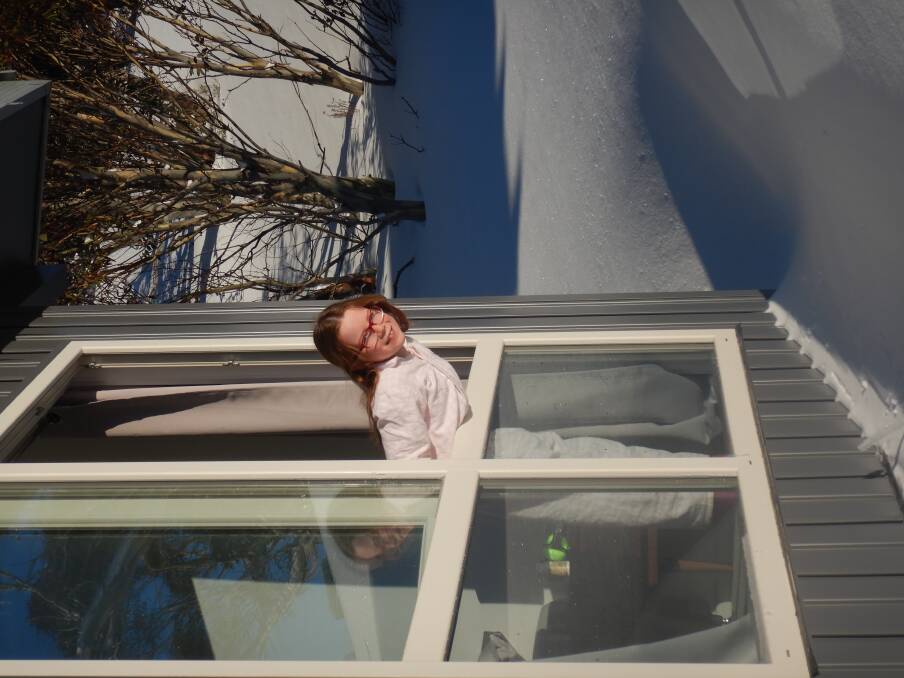 Emily peers out her window at Numbananga Lodge to find a fresh dump of snow. Photo: Tim the Yowie Man