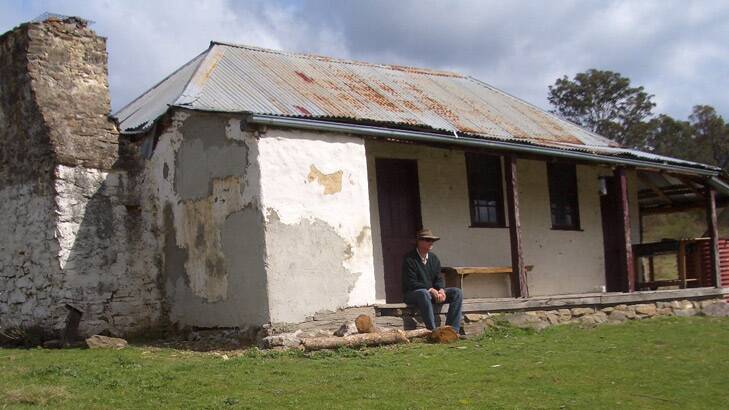 The present version of Cotter's original hut at `The Forest'. Great-great grandson Liam Cotter sits on the verandah.