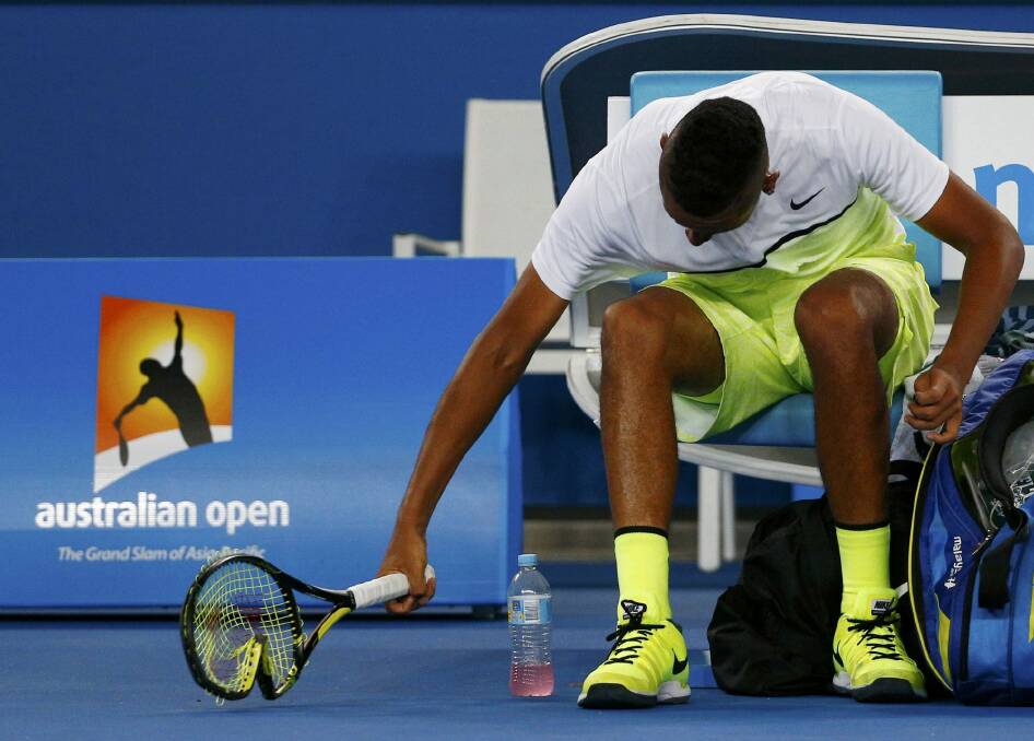 Smash it up: Nick Kyrgios breaks a racquet on Monday night. Photo: Reuters