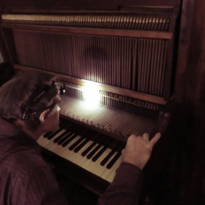 Piano technician Chris Leslie investigates the condition of the action on the Lanyon Homestead's piano. Photo: Supplied
