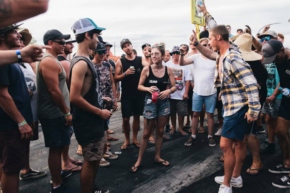 A group of men surround a young woman and shout 'black top, black top' requesting she remove her top. She didn't remove her top. Photo: Rohan Thomson