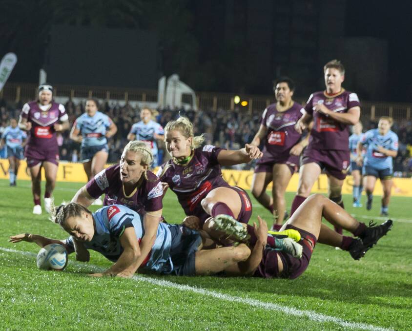 No stopping her: Isabelle Kelly defies the Maroons opposition to score her second try to seal victory for the Blues. Photo: AAP