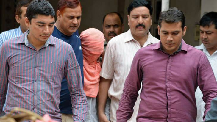 Indian policemen escort the juvenile in pink hood, accused in the December 2012 gang-rape of a student, following his guilty verdict at a court in Delhi. Photo: AFP