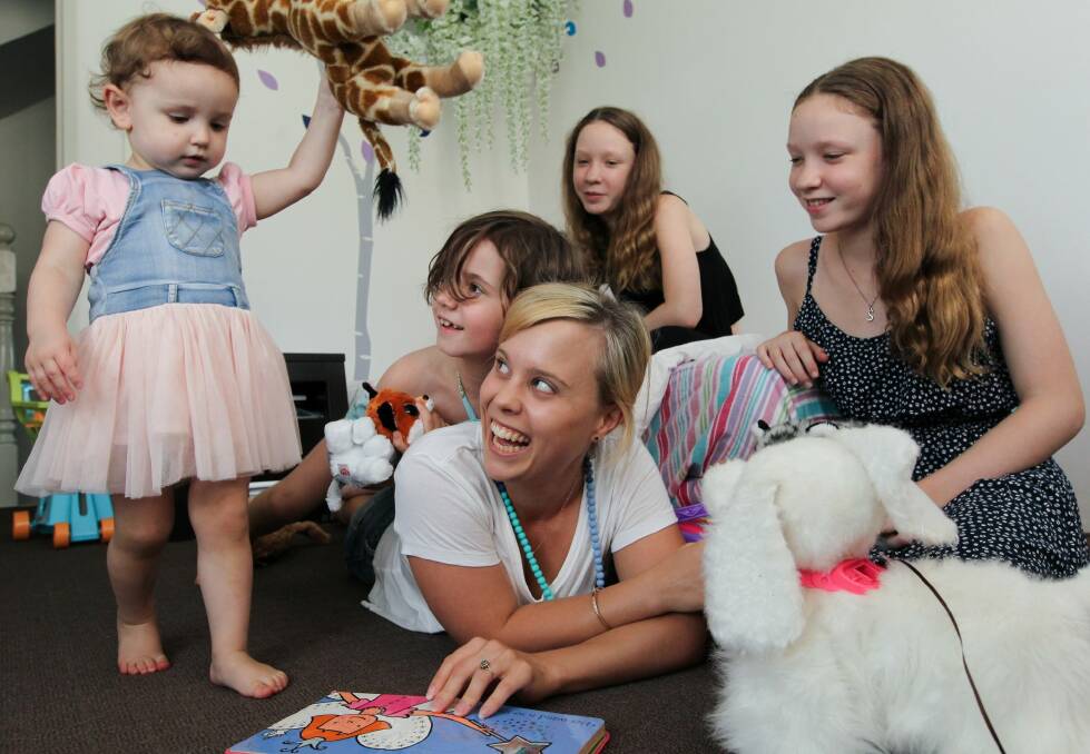 Nanny Hope Skinner, with Vivienne, 22 months, Charlie, 7, and twins Imogen and Sheridan, 12, in their North Sydney home. Experts are concerned that proposed funding for childcare will leave families worse off. Photo: Janie Barrett