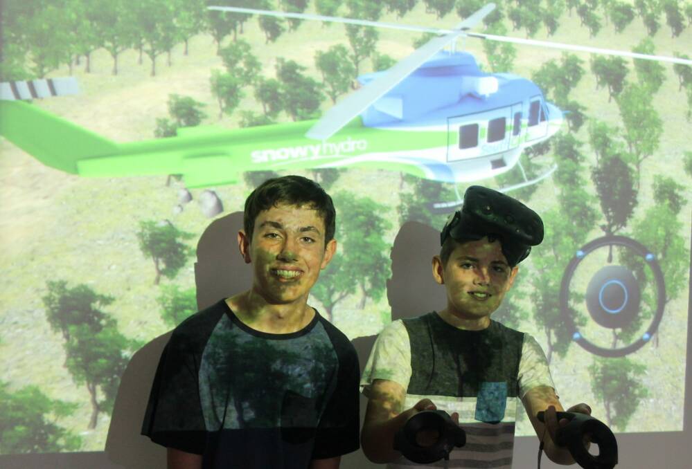 Joshua Edye,15 with his brother Kaiden, 12 playing a Snowy Hydro Southcare simulation game. Photo: Georgina Connery
