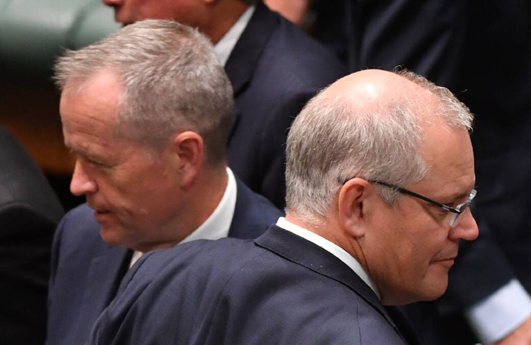 Prime Minister Scott Morrison (right) crosses paths with Opposition Leader Bill Shorten at Parliament House. Photo: AAP