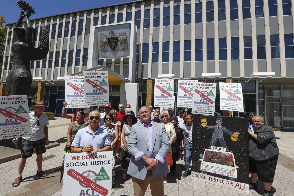 Chairman of the ACT Taxi Plates Owners Association Petar Ivanovski (centre) with taxi plate owners rally in front of the Legislative Assembly. Photo: Sitthixay Ditthavong