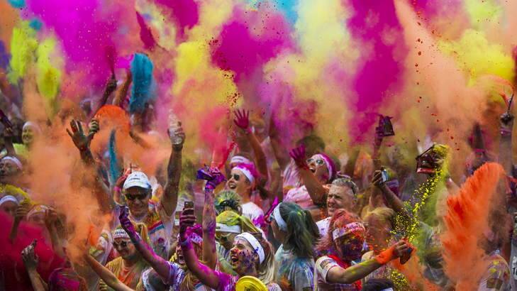 Crowds throw packets of coloured cornstarch during the celebrations at the Color Run at Commonwealth Park. Photo: Rohan Thompson