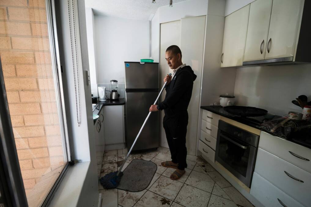 Sangay Yeser cleaning his apartment after flooding in O'Connor.  Photo: Dion Georgopoulos