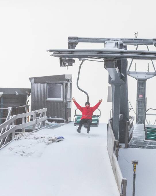 A Thredbo visitor gets ready to ride the chairlift after 5cm of fresh snow fell at the weekend. Photo: Thredbo