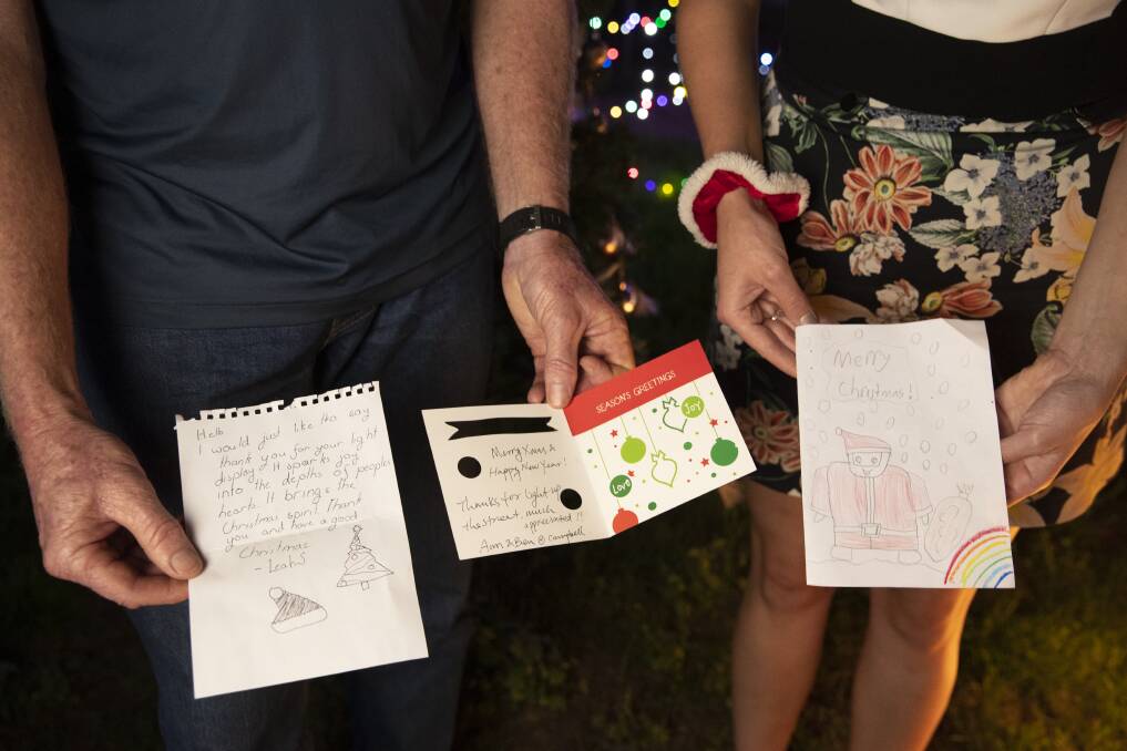 Scott and Lindsay McAlister show letters and cards they received from children in the area saying how much the Christmas lights were appreciated. Photo: Sitthixay Ditthavong