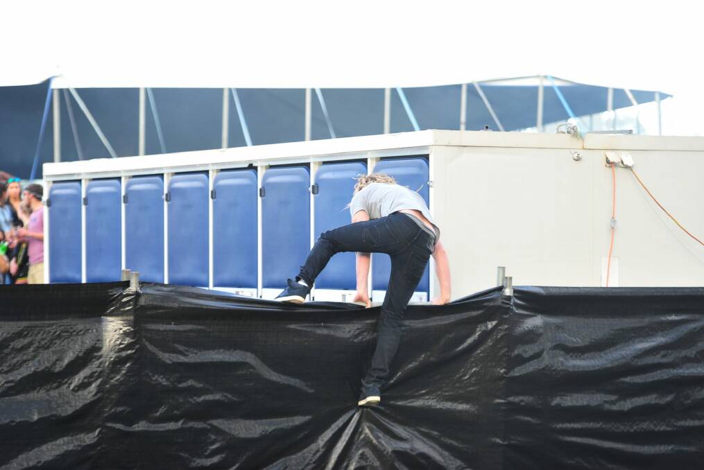 A person attempts to jump the fence at Groovin the Moo in Canberra. Photo: Melissa Adams