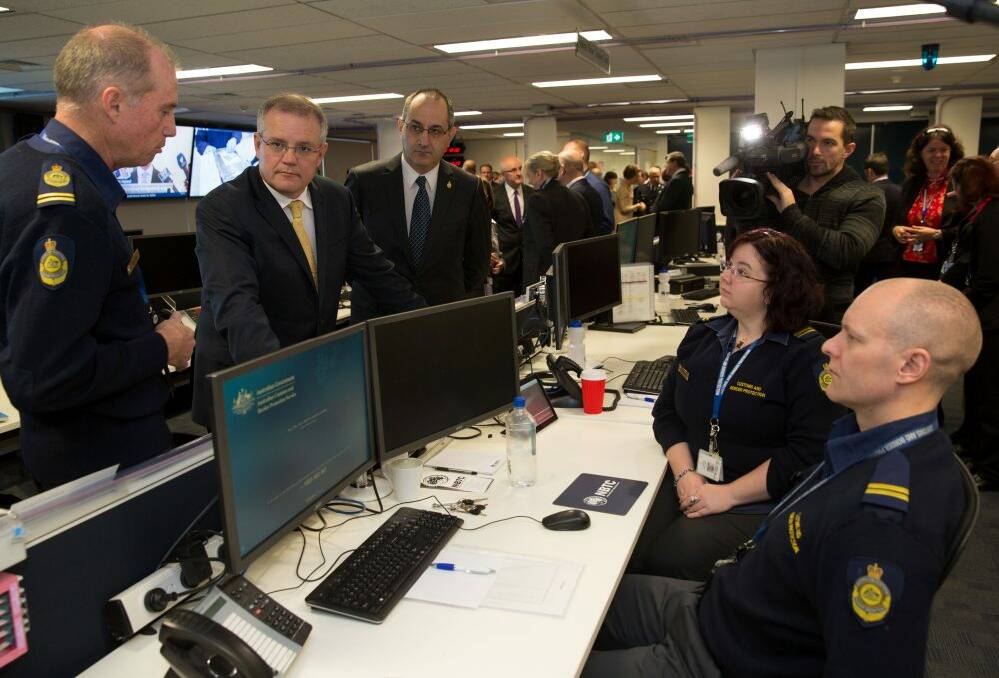 Minister for Immigration and Border Protection Scott Morrison and acting-Commander of Strategic Border Protection Terry Price talk with operations officers at the National Border Targeting Centre launch in Canberra. Photo: Andrew Taylor