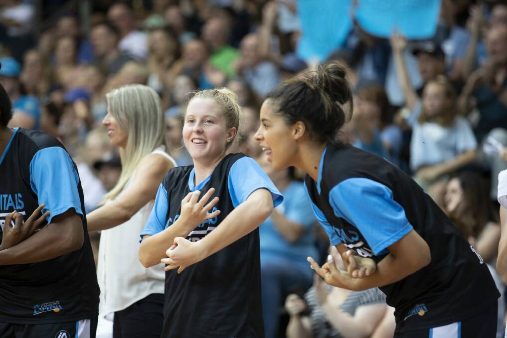 The Canberra Capitals bench react to a Leilani Mitchell triple - pretending to nurse a baby. Photo: Sitthixay Ditthavong