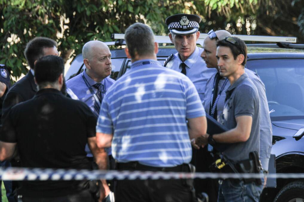 Police Inspector Daniel Bragg (second from right) speaks with fellow officers at the scene. Photo: Jorge Branco