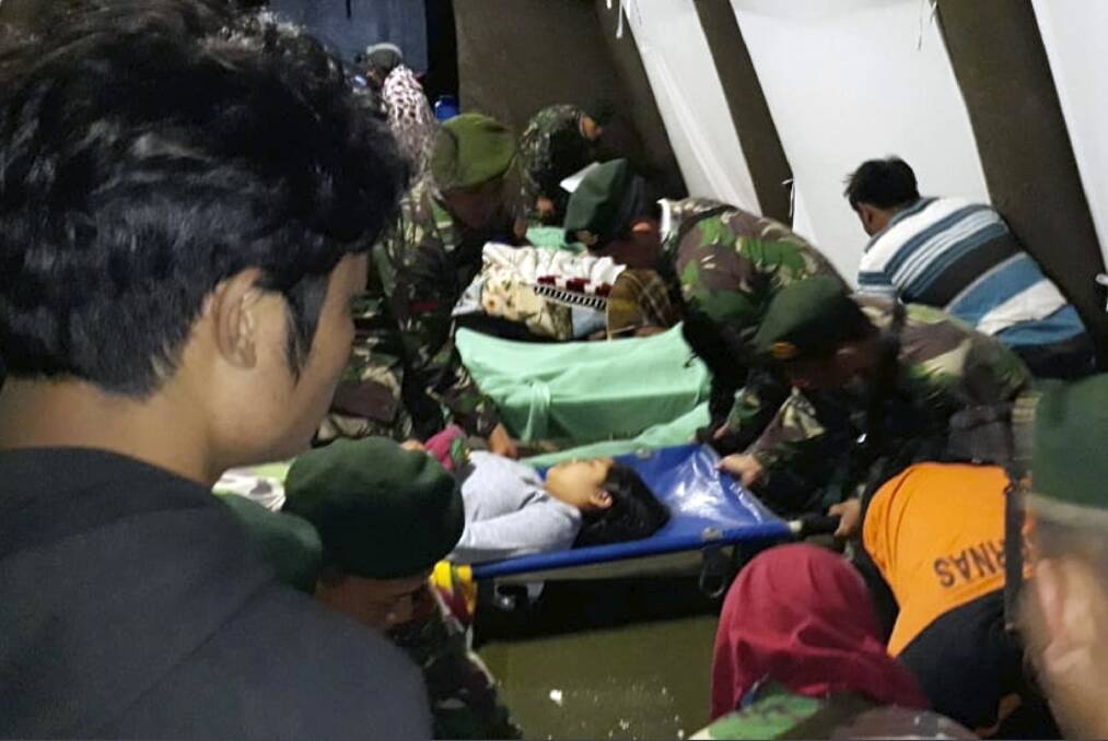 Indonesian soldiers tend to a woman injured in the earthquake at a makeshift hospital in Lombok. Photo: AP