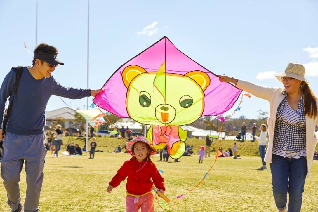 Rui Man, Cherie He, 2, and Xin He enjoy the kites at Flying High in Googong. Photo: Supplied