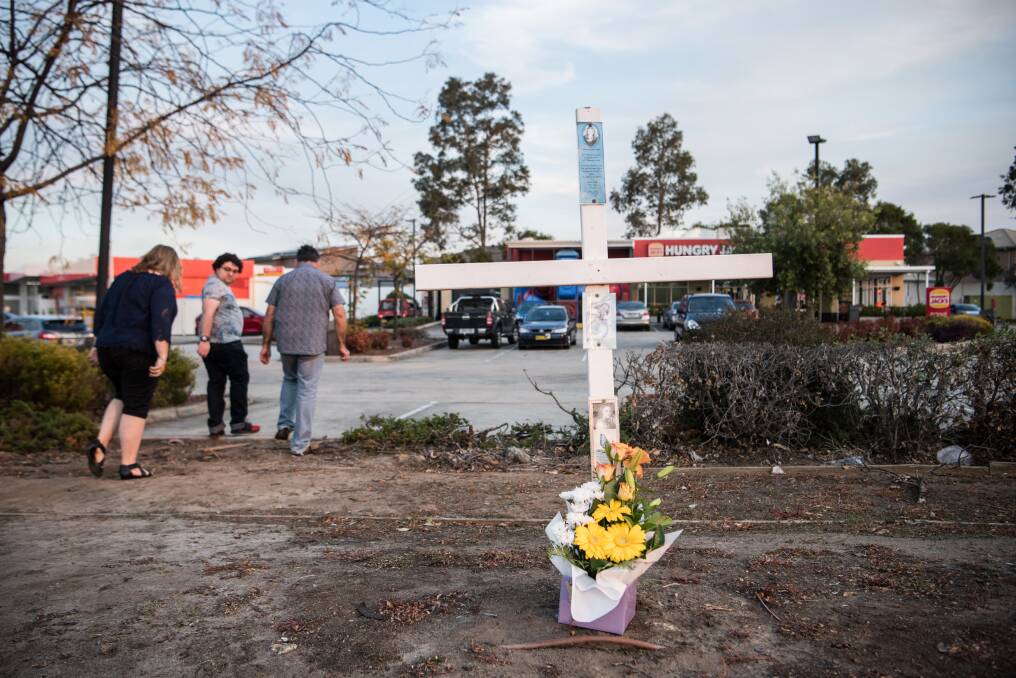 A cross outside the Hungry Jack’s car park in southwest Sydney marks the spot where police shot Courtney Topic. Photo:  Wolter Peeters