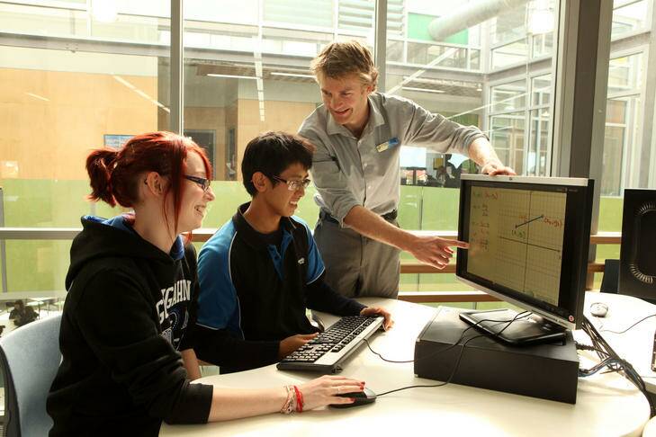 Teacher Peter Smythe with students Hayley Stensholt, 17 and Huan Tran, 16, at Gungahlin College. Photo: Penny Bradfield