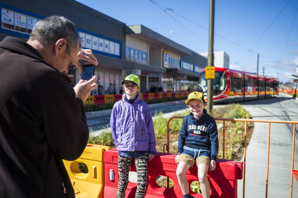 Angelique Corbitt, 10, and James Corbitt, 7, having their photo taken in front of the new tram. Photo: Dion Georgopoulos