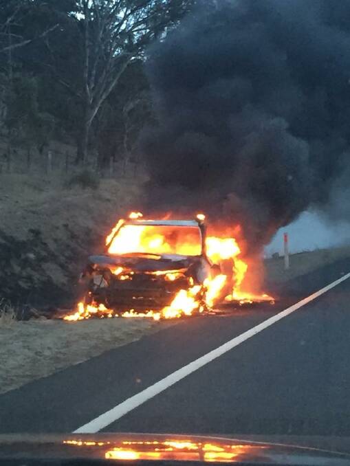 A car sits ablaze on the Monaro Highway near Michelago after hitting a kangaroo on Monday morning. Photo: Mary Boileau