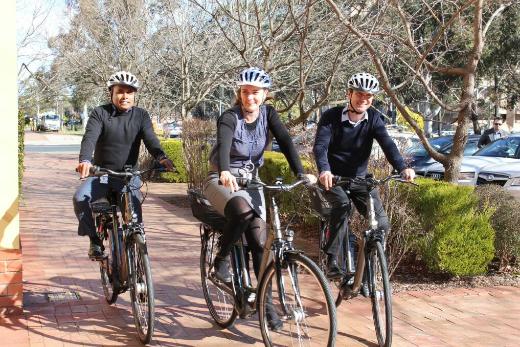 The trial of pedal-assisted electric bicycles, or e-bikes, is being rolled out across ACT government workplaces. Udaya Kumar, left, Nicola Plunkett-Cole and Richard Horton try them out. Photo: Supplied