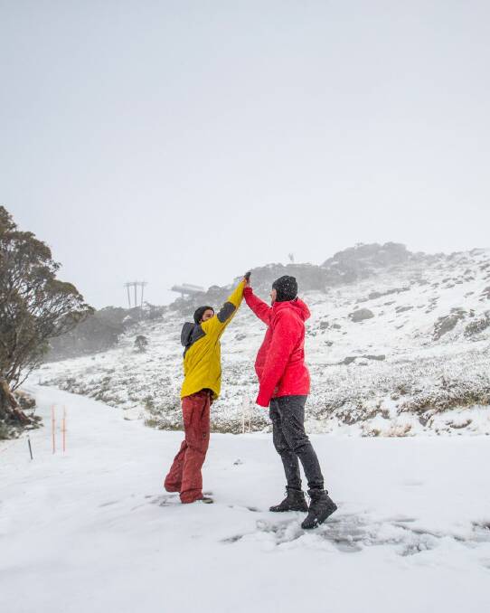 Thredbo visitors celebrate 5cm of fresh snow with a high-five. Photo: Thredbo