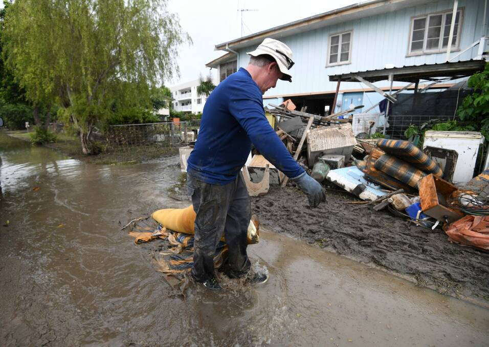 Chris Mitchell removes flood damaged items out of his father in-law's house in the suburb of Rosslea in  flood-affected Townsville Photo: Dan Peled/AAP