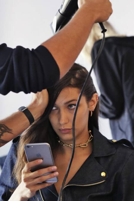 Model Bella Hadid has her hair styled backstage before the Michael Kors Spring 2017 collection. Photo: AP