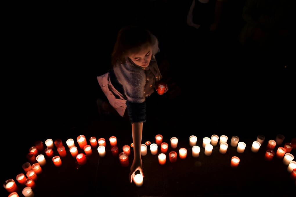 A girl places a candle in tribute last year for the people who died in the attack on Guernica. Photo: Alvaro Barrientos