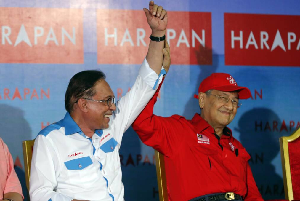 Malaysia's Prime Minister Mahathir Mohamad, right, raises hand of Malaysia's reform icon Anwar Ibrahim during a rally in Port Dickson, last week. Photo: AP