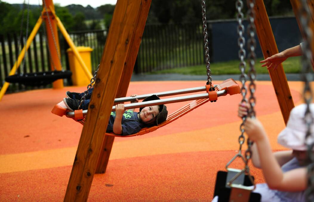 Owen  Smith, 2, enjoys the swing at Boundless Canberra playground. Photo: Melissa Adams