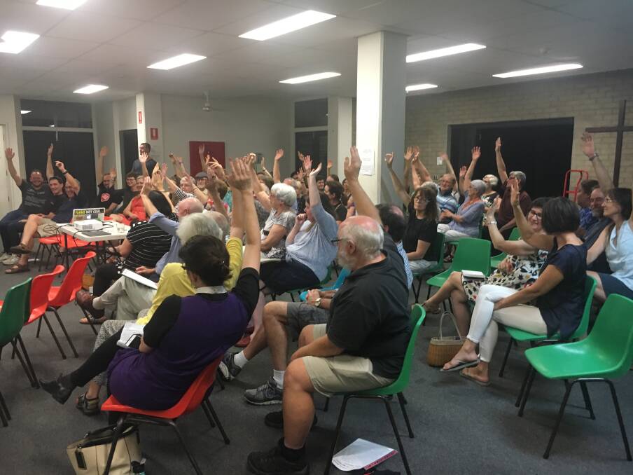 More than 50 residents raise their hands to indicate support for a boycott of the the Pig ‘N’ Whistle pub. Photo: Lydia Lynch