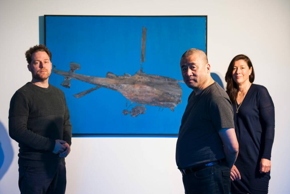 Painting titled 'Flying Machine' is the centrepiece of 'Zhang Peili: from Painting to Video' exhibition at the Australian National University. Pictured with co-curators Olivier Krischer and Kim Machan. Photo: Elesa Kurtz